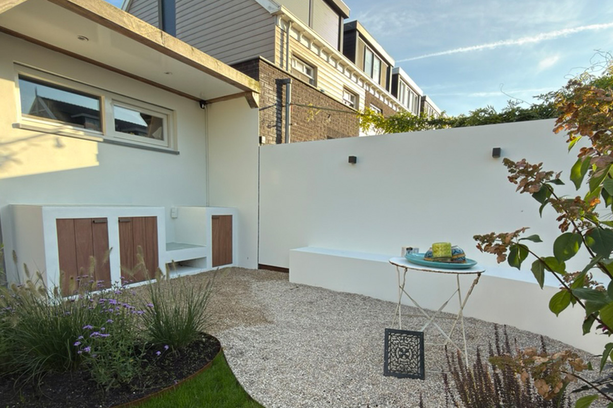 Minimalist courtyard garden project featuring white walls, wooden storage doors, gravel surfaces, and modern landscaping