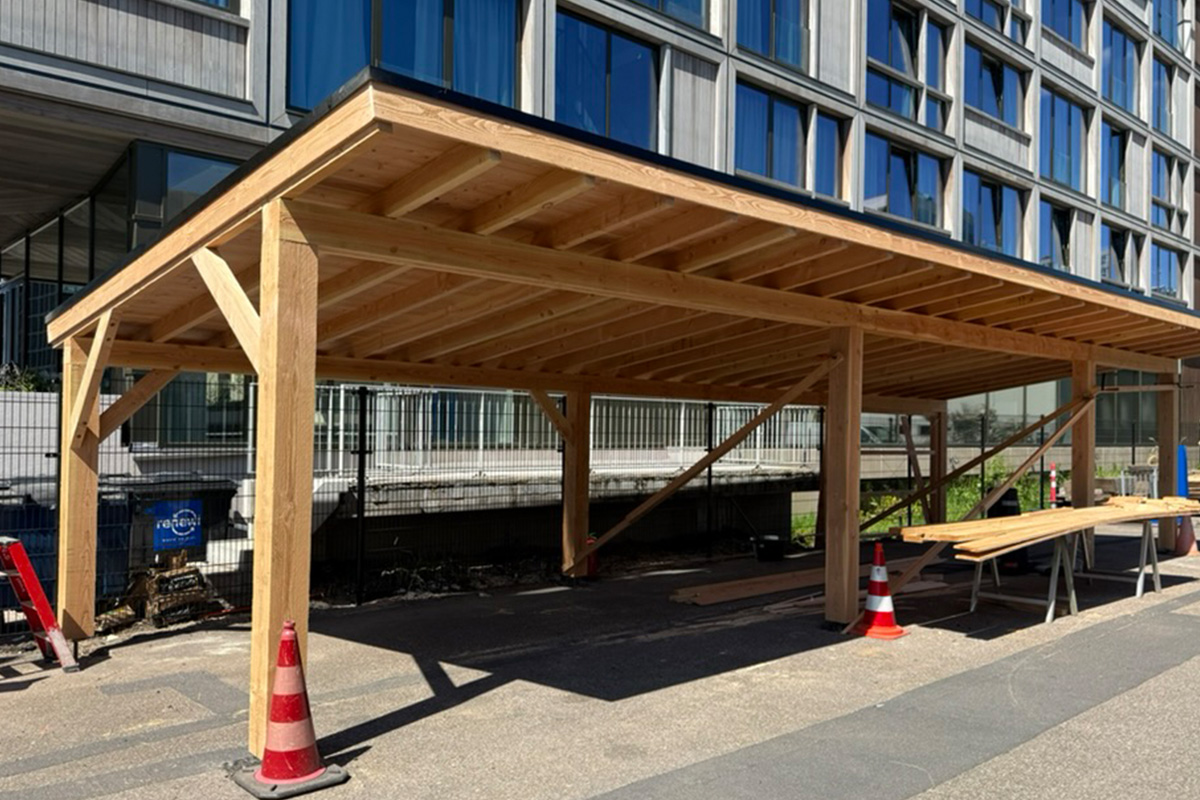 Large-scale custom wooden carport construction project featuring substantial timber frame structure and professional craftsmanship