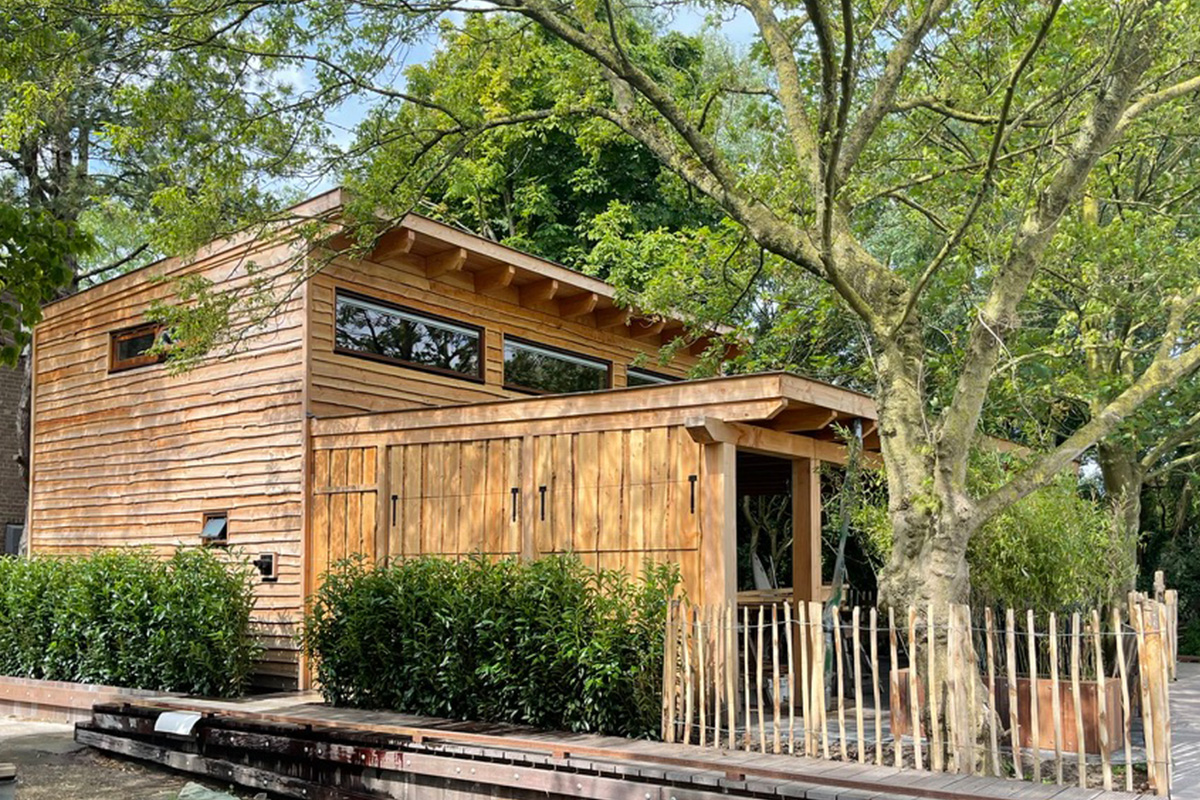Custom wooden garden structure project featuring horizontal wood siding, large windows, and modern architectural design