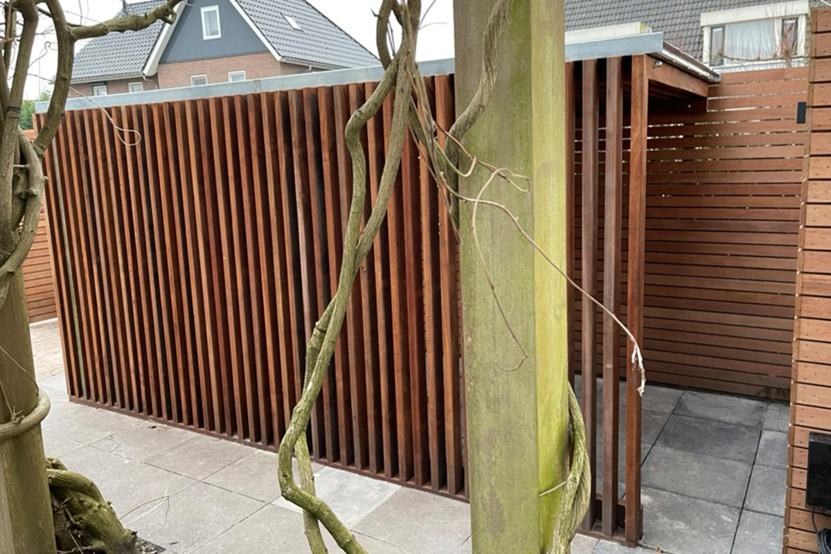 Custom wooden slat fence project featuring vertical wooden slats integrated around existing trees